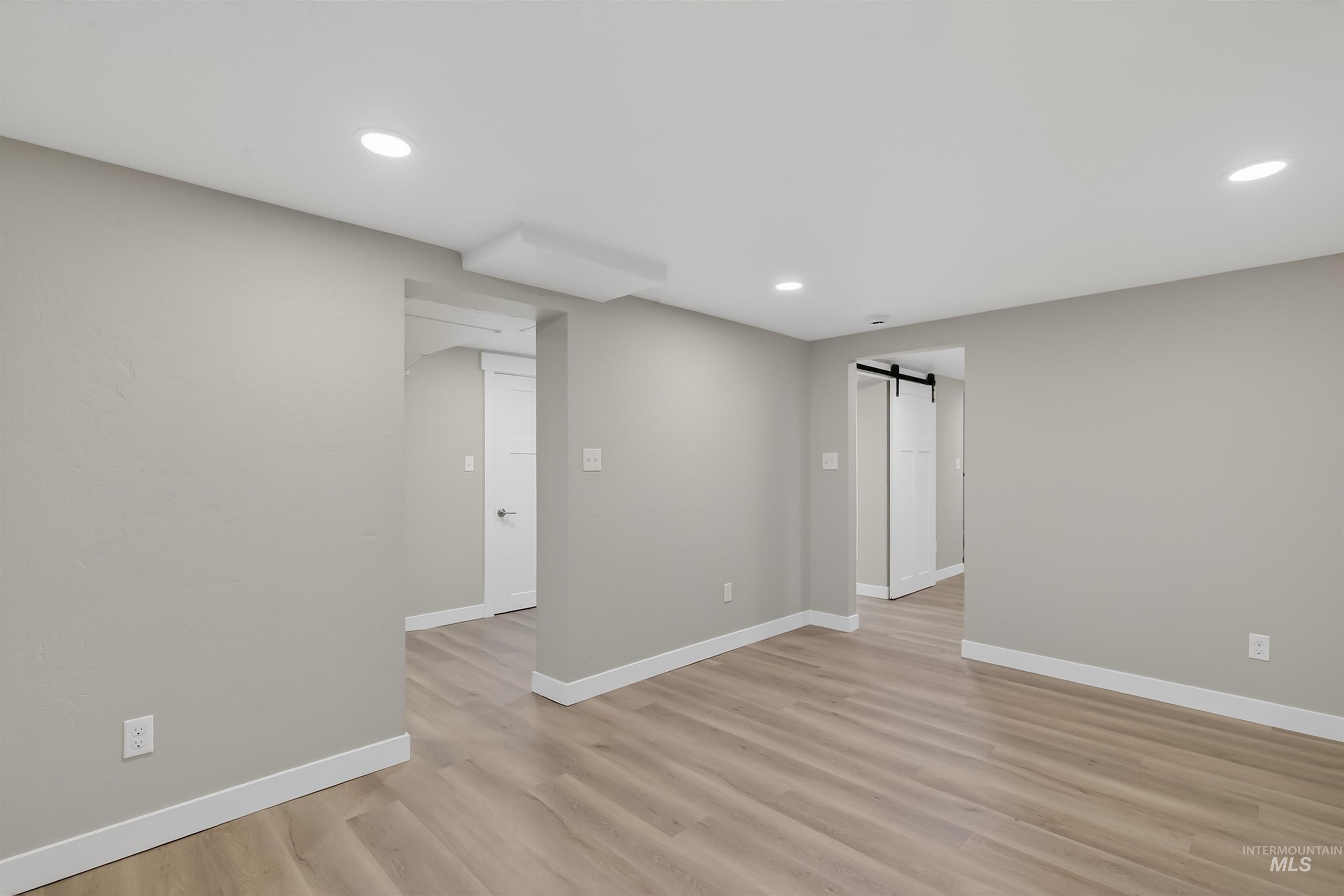 929 10th Street Clarkston, WA 99403 - Photo 32 of 43 Spare room with a barn door, light wood-type flooring, and recessed lighting