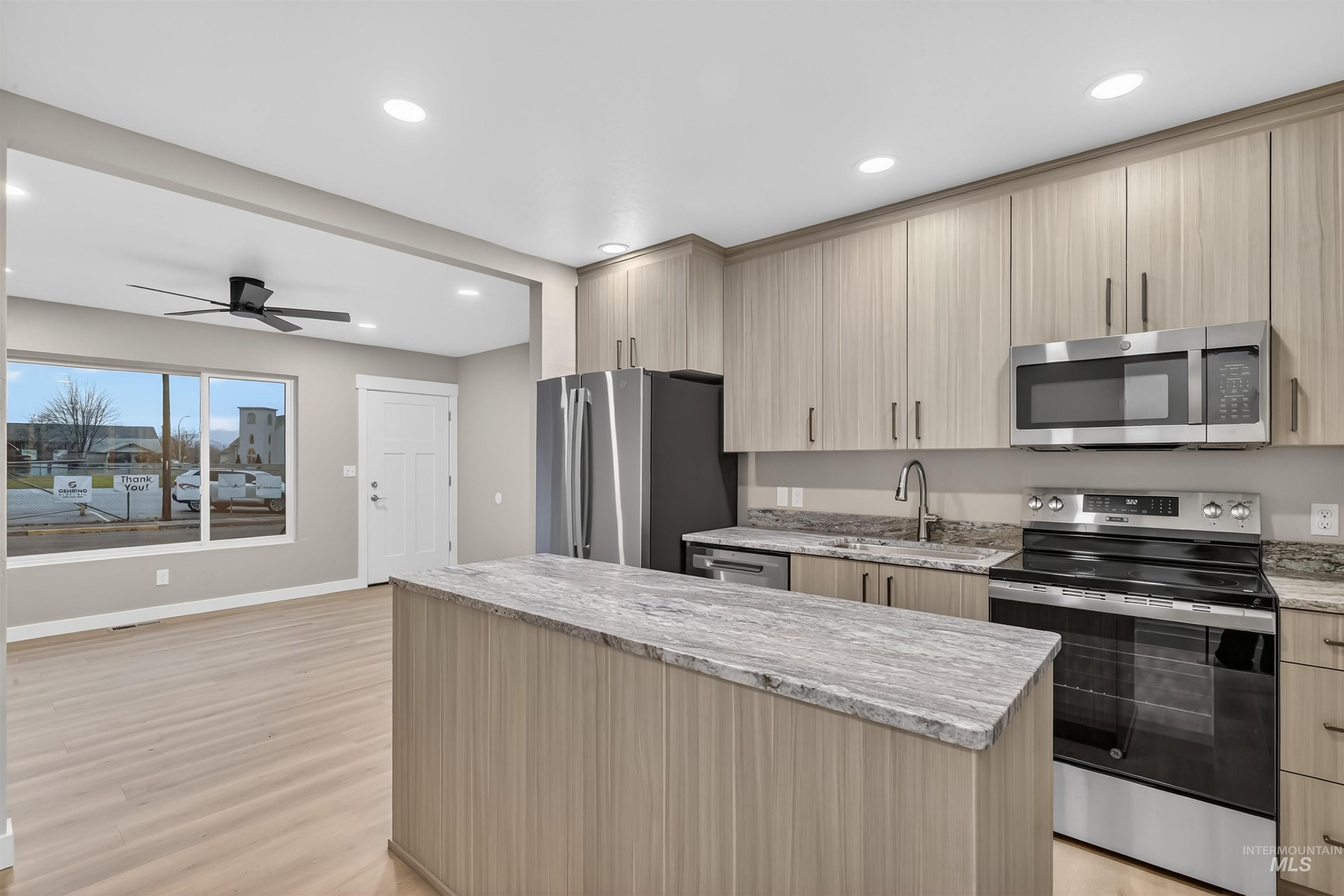 929 10th Street Clarkston, WA 99403 - Photo 7 of 43 Kitchen featuring appliances with stainless steel finishes, light stone countertops, a kitchen island, recessed lighting, and modern cabinets