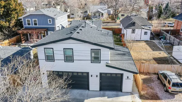 a view of a big house with wooden fence