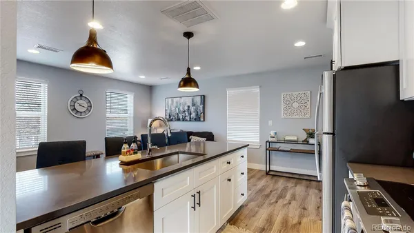 a kitchen with stainless steel appliances a sink stove and refrigerator