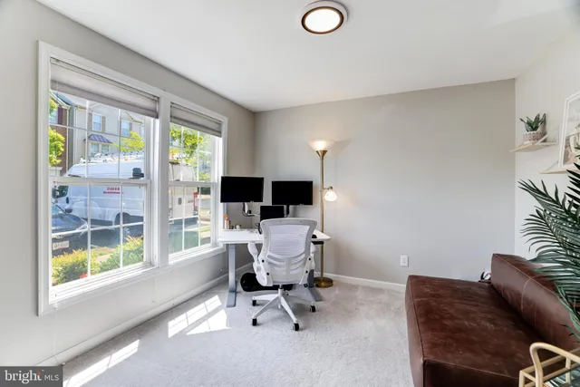 a view of a livingroom with workspace and a window