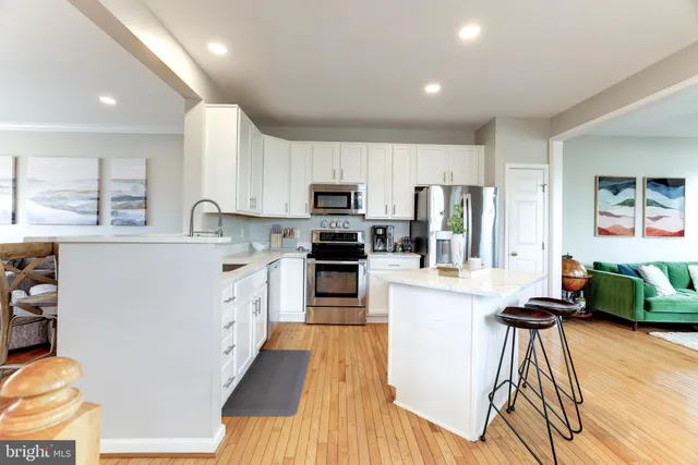 a kitchen with kitchen island granite countertop wooden floors and stainless steel appliances