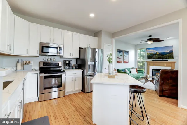 a kitchen with granite countertop wooden floors a stove and a refrigerator