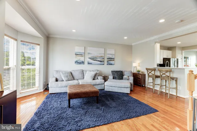 a living room with furniture wooden floor and a large window