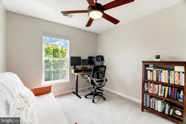 a view of a workspace with furniture and a bookshelf