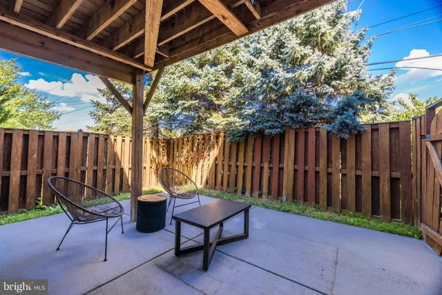 a view of a chairs and table in the back yard of the house