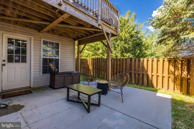 a view of a chairs and table in the back yard of the house