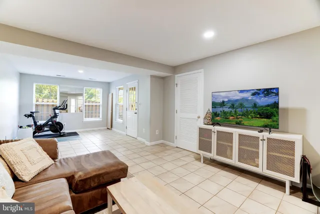 a living room with furniture a flat screen tv and a floor to ceiling window