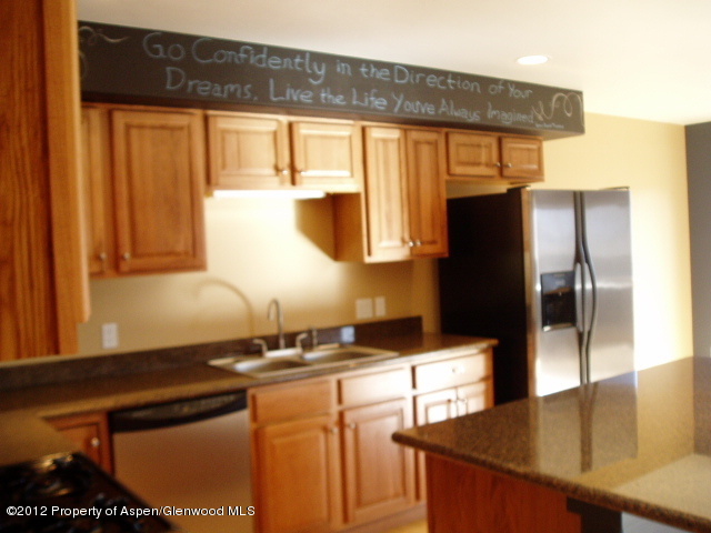 668 Alder Ridge Lane New Castle, CO 81647 - Photo 4 of 30 a kitchen with stainless steel appliances granite countertop a refrigerator a stove and a sink with wooden floor