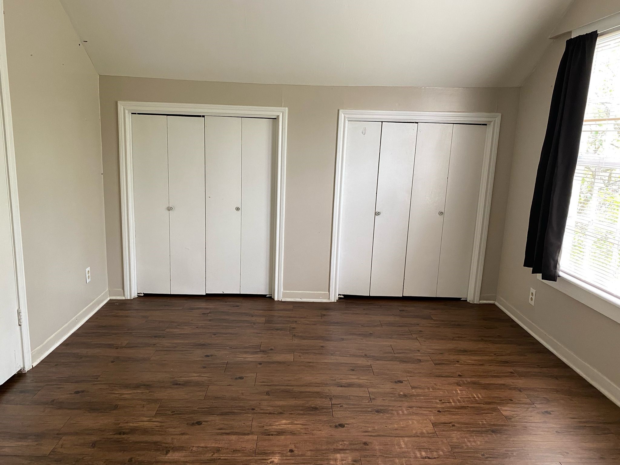 800 Travis Street, Unit ATTIC Columbus, TX 78934 - Photo 6 of 9 a view of an empty room with wooden floor and a window
