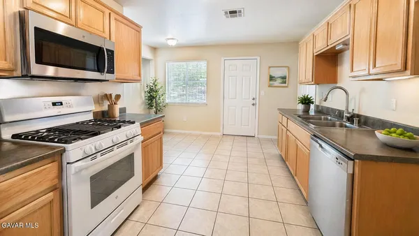 a kitchen with stainless steel appliances granite countertop a stove a sink and a microwave