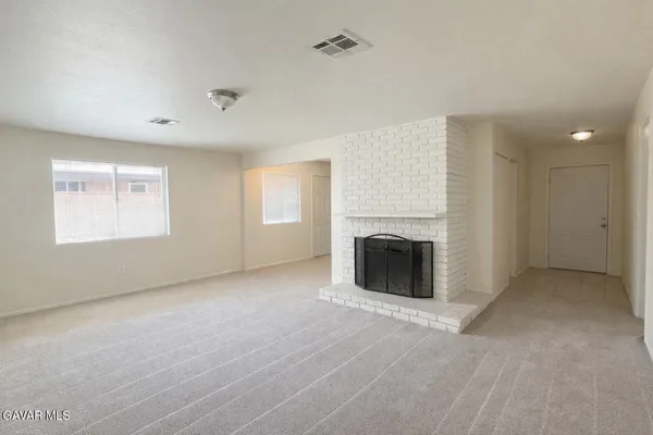 an empty room with windows fireplace and windows