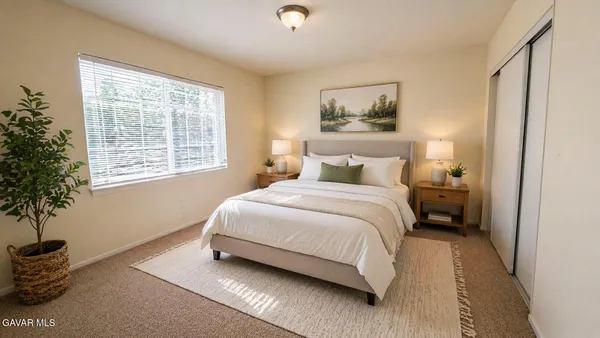 a bedroom with a bed and a potted plant