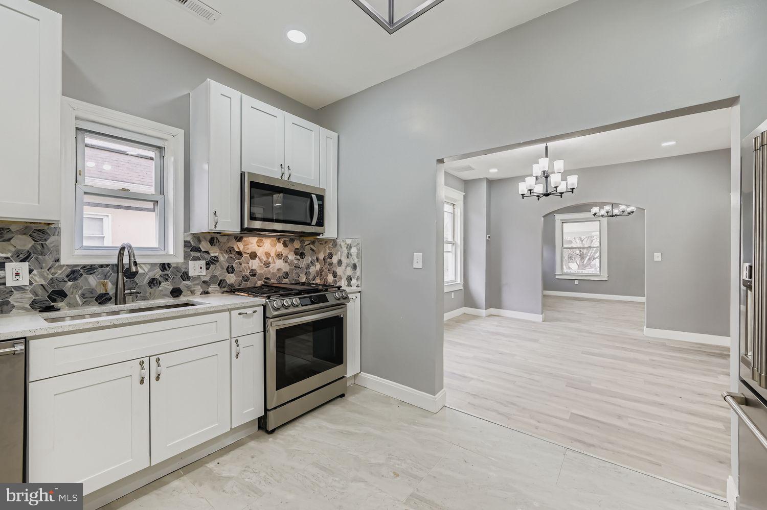 4111 Penhurst Avenue Baltimore, MD 21215 - Photo 14 of 39 a kitchen with stainless steel appliances granite countertop a stove sink and cabinets