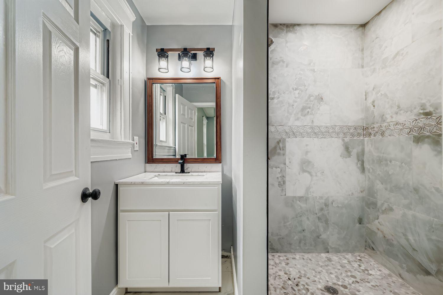 4111 Penhurst Avenue Baltimore, MD 21215 - Photo 17 of 39 a bathroom with a sink vanity and shower