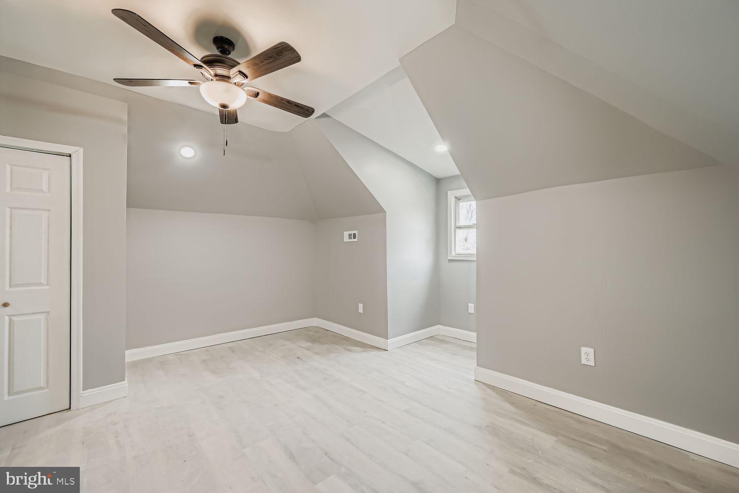 4111 Penhurst Avenue Baltimore, MD 21215 - Photo 24 of 39 an empty room with a chandelier fan and wooden floor