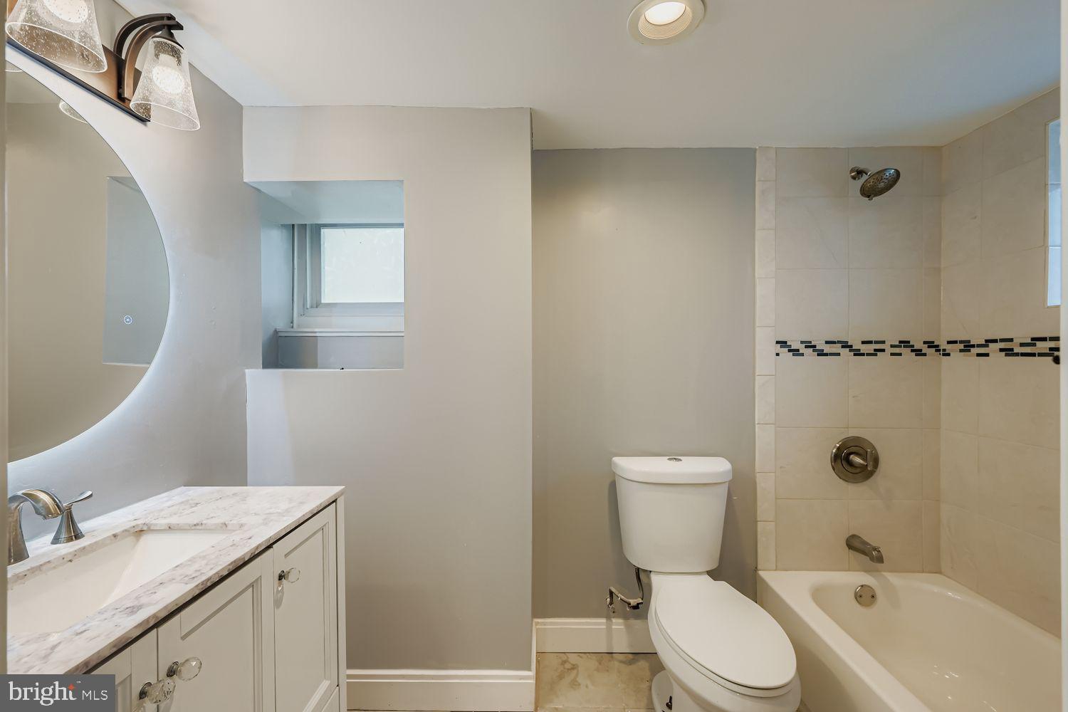4111 Penhurst Avenue Baltimore, MD 21215 - Photo 31 of 39 a bathroom with a granite countertop toilet sink and mirror