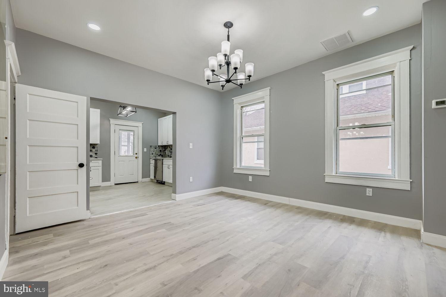 4111 Penhurst Avenue Baltimore, MD 21215 - Photo 8 of 39 an empty room with chandelier and windows