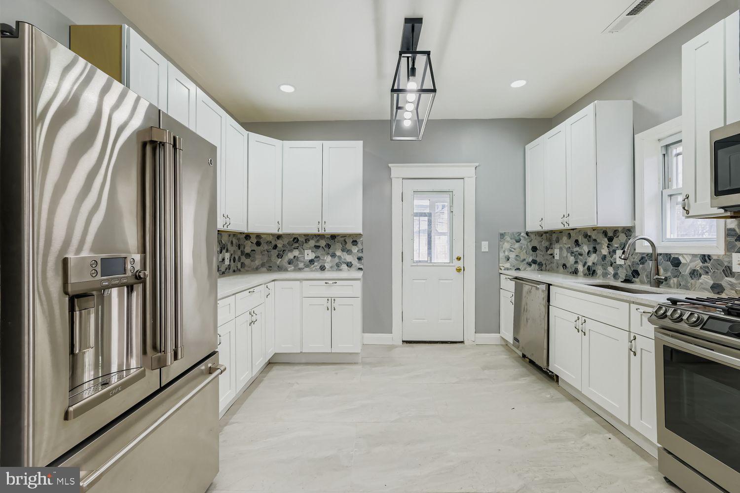 4111 Penhurst Avenue Baltimore, MD 21215 - Photo 9 of 39 a kitchen with white cabinets and stainless steel appliances