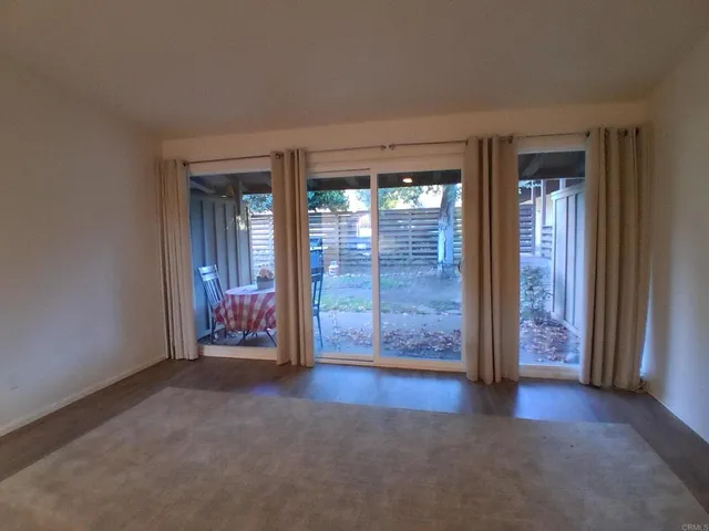 an empty room with windows wooden wall and door