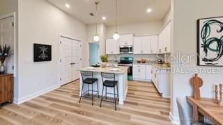 1791 Roberts Trail Bell, FL 32619 - Photo 25 of 28 a kitchen with stainless steel appliances kitchen island granite countertop a stove a sink a dining table and chairs with wooden floor