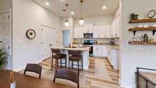1791 Roberts Trail Bell, FL 32619 - Photo 26 of 28 a kitchen with stainless steel appliances kitchen island granite countertop a stove a sink a dining table and chairs with wooden floor