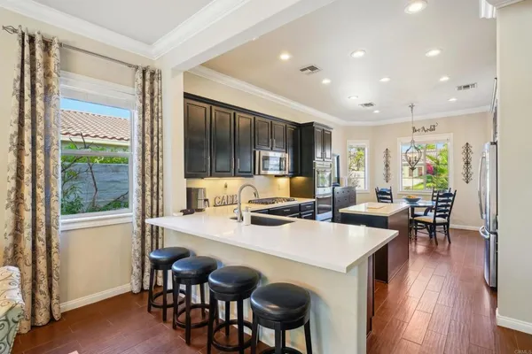 a kitchen with stainless steel appliances a stove sink microwave refrigerator and cabinets