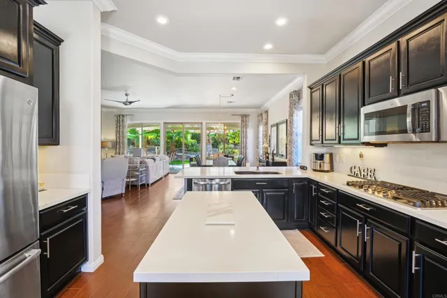 a kitchen with stainless steel appliances granite countertop sink stove top oven and cabinets
