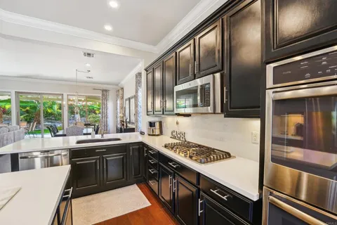 a kitchen with granite countertop a refrigerator stove microwave and cabinets