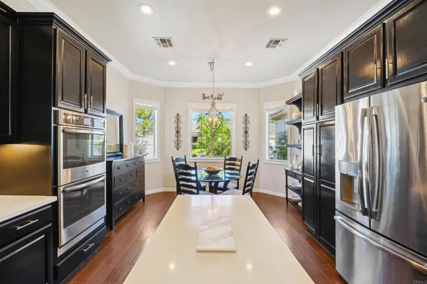 a kitchen with a dining table chairs sink and wooden floor