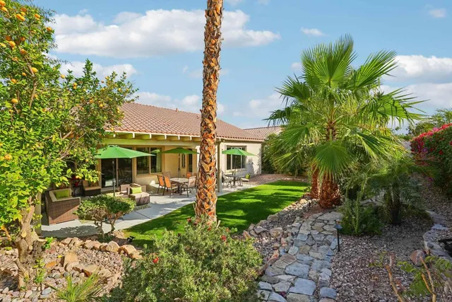 a view of a patio with table and chairs under an umbrella