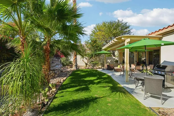 a view of an house with backyard and sitting area