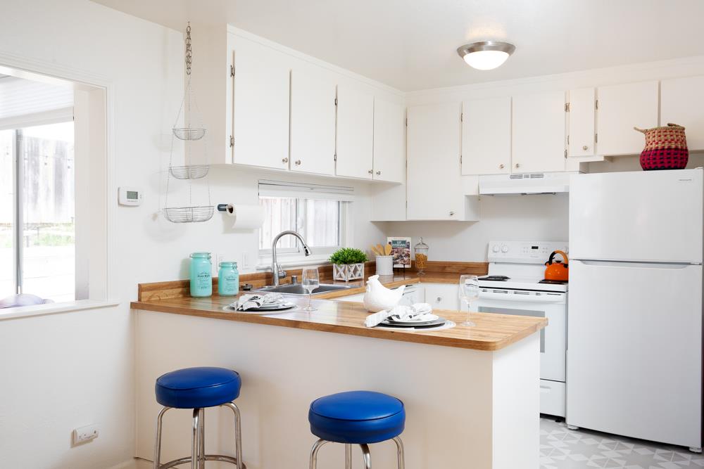 380 Sea Ridge Road, Unit E Aptos, CA 95003 - Photo 17 of 27 a kitchen with stainless steel appliances granite countertop a sink a stove a refrigerator a white table and chairs