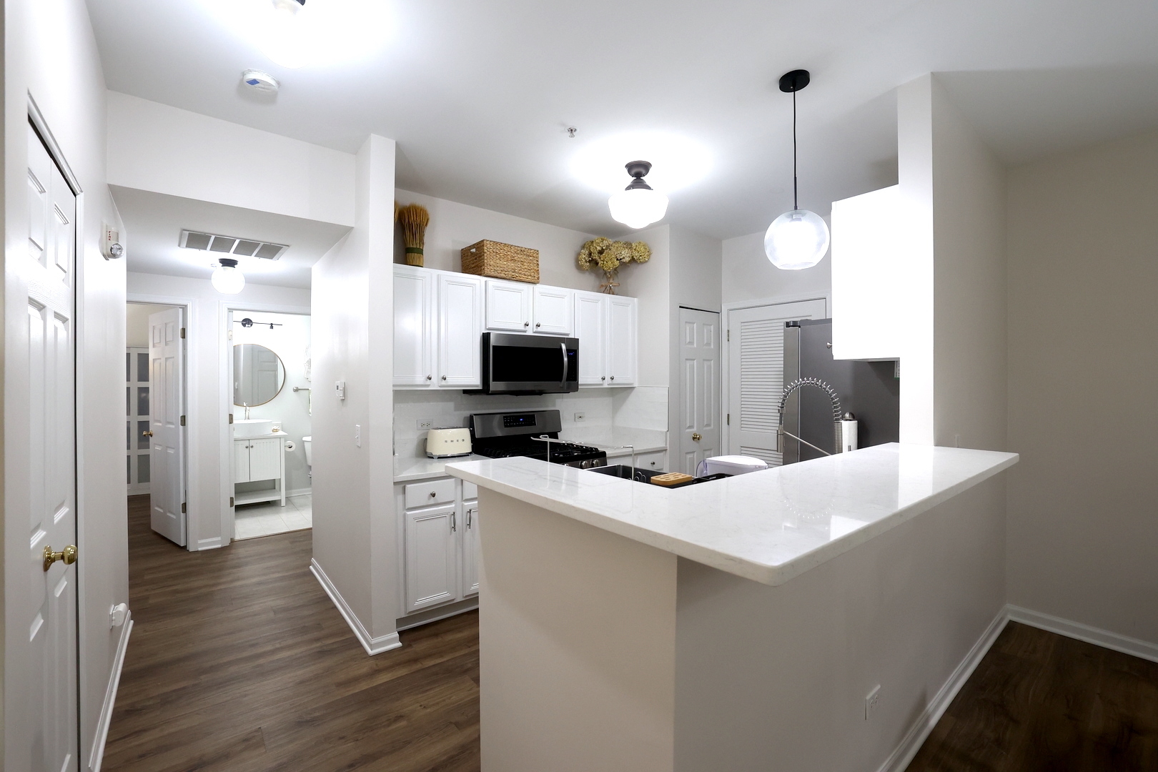 650 Mill Circle, Unit 103 Wheeling, IL 60090 - Photo 9 of 14 a kitchen with stainless steel appliances a stove top oven a refrigerator a sink and white cabinets with wooden floor