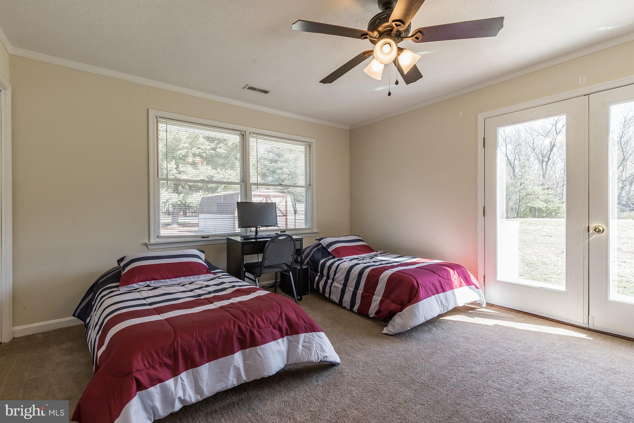 3142 Soper Road Huntingtown, MD 20639 - Photo 11 of 30 a bedroom with two beds and a chandelier