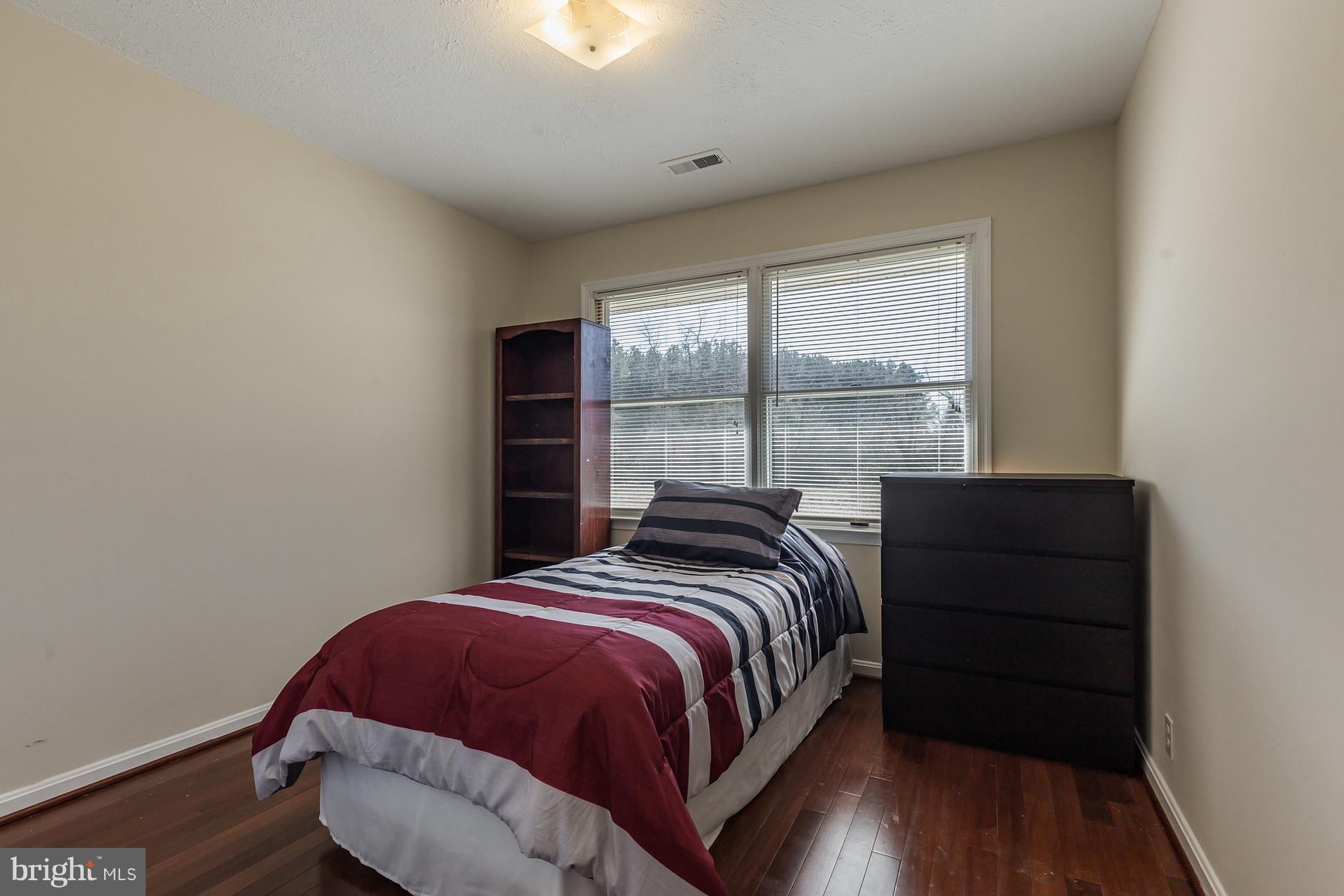 3142 Soper Road Huntingtown, MD 20639 - Photo 14 of 30 a bed sitting in a bedroom next to a window
