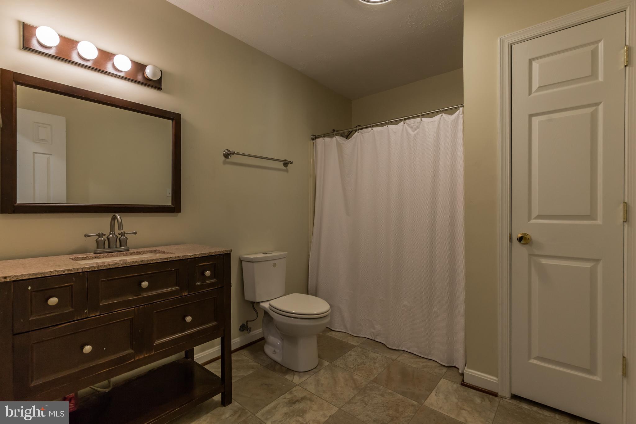 3142 Soper Road Huntingtown, MD 20639 - Photo 15 of 30 a bathroom with a toilet a sink a mirror and vanity