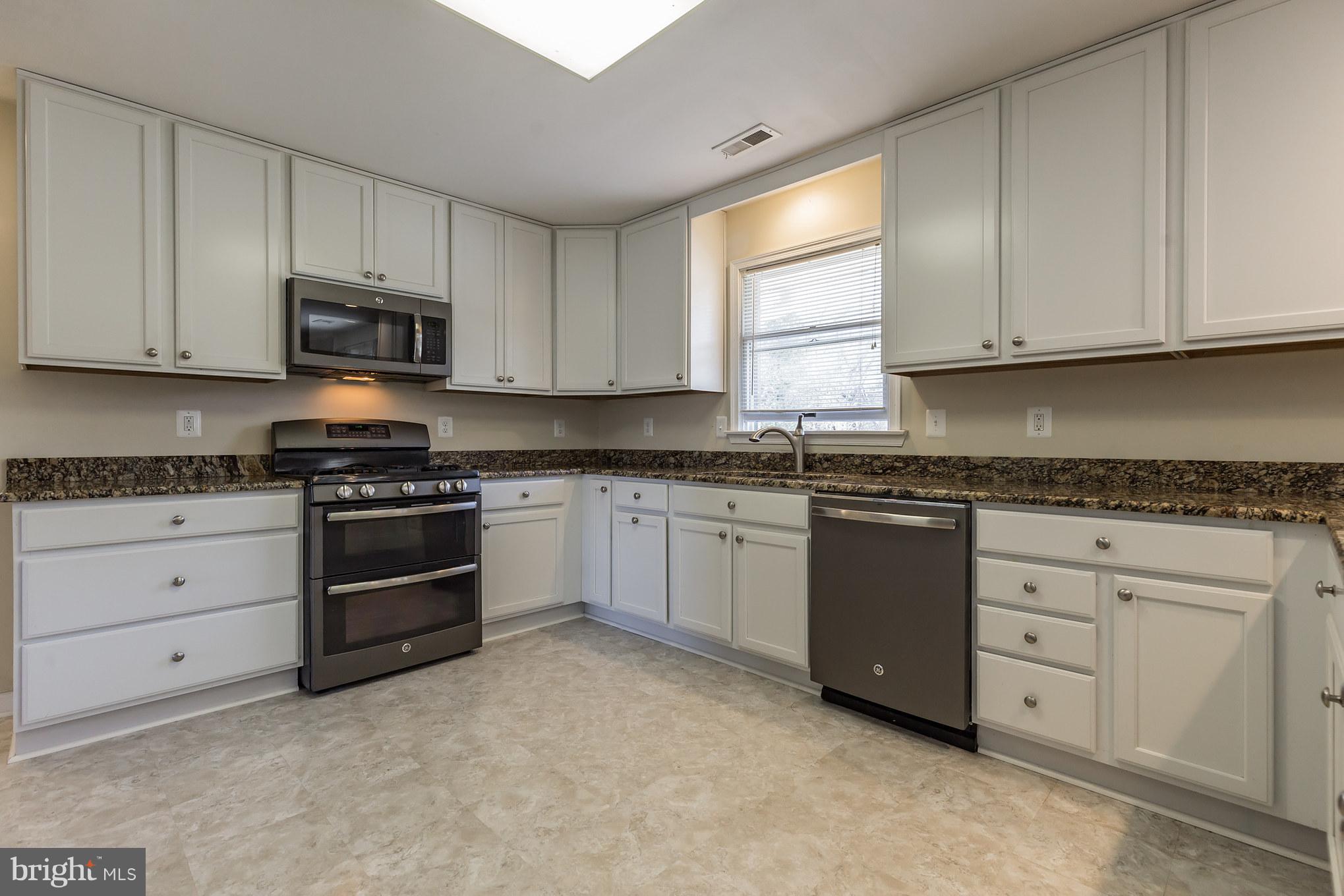 3142 Soper Road Huntingtown, MD 20639 - Photo 22 of 30 a kitchen with granite countertop white cabinets and stainless steel appliances