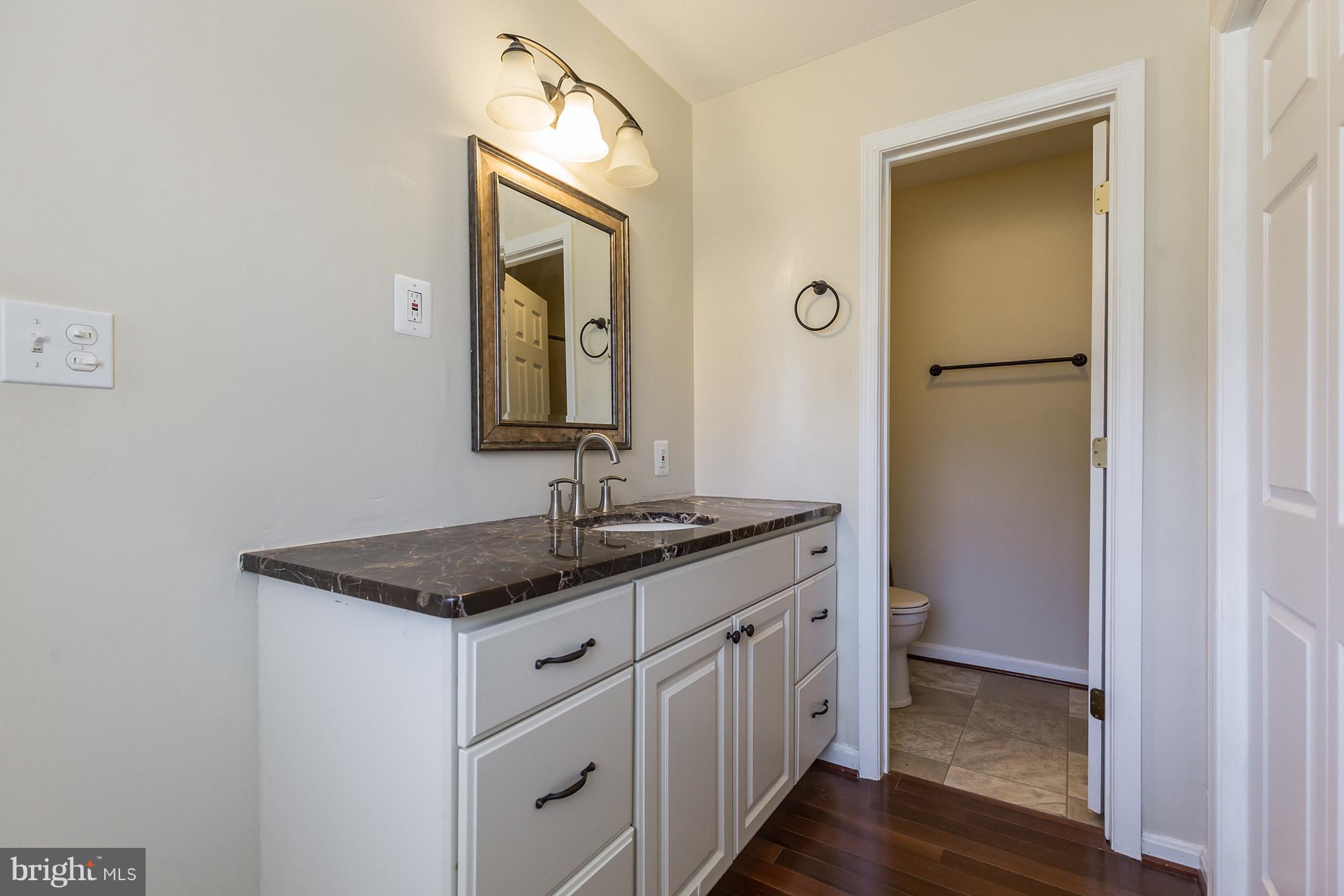 3142 Soper Road Huntingtown, MD 20639 - Photo 24 of 30 a bathroom with a granite countertop sink a mirror and a