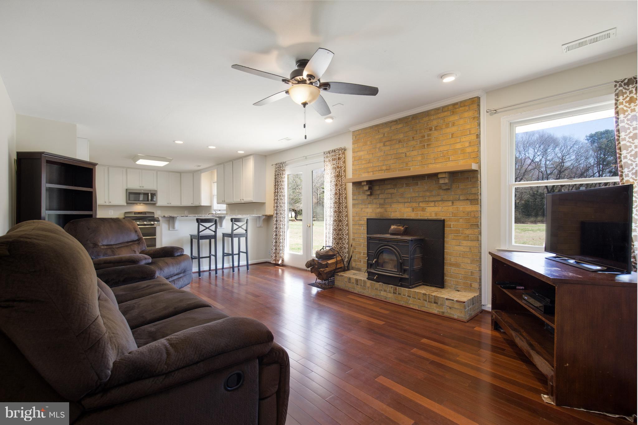 3142 Soper Road Huntingtown, MD 20639 - Photo 5 of 30 a living room with furniture a fireplace and a flat screen tv