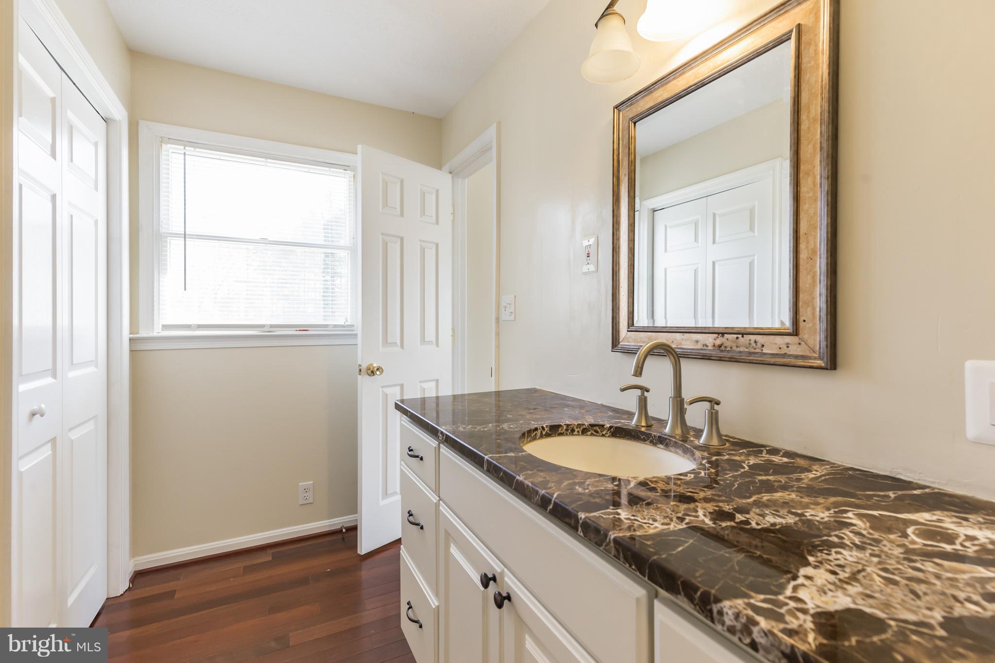 3142 Soper Road Huntingtown, MD 20639 - Photo 10 of 30 a bathroom with a granite countertop sink and a mirror