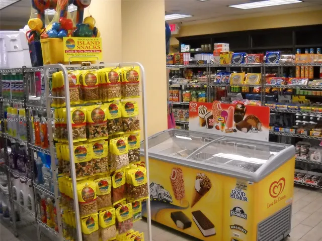 a living room with couches and kitchen view with wooden floor