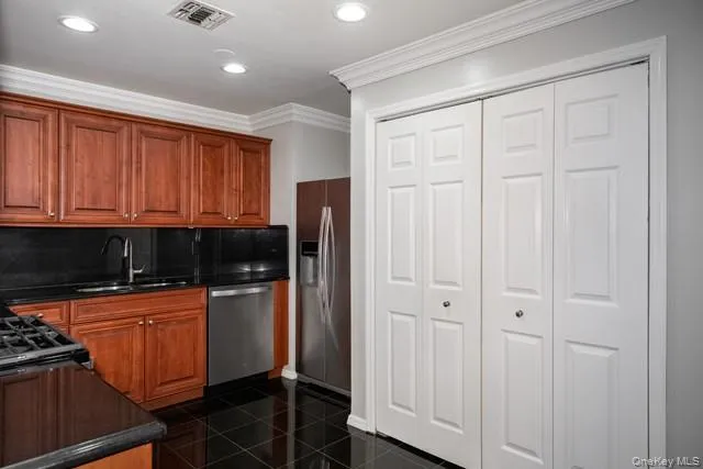 a kitchen with stainless steel appliances granite countertop white cabinets and refrigerator