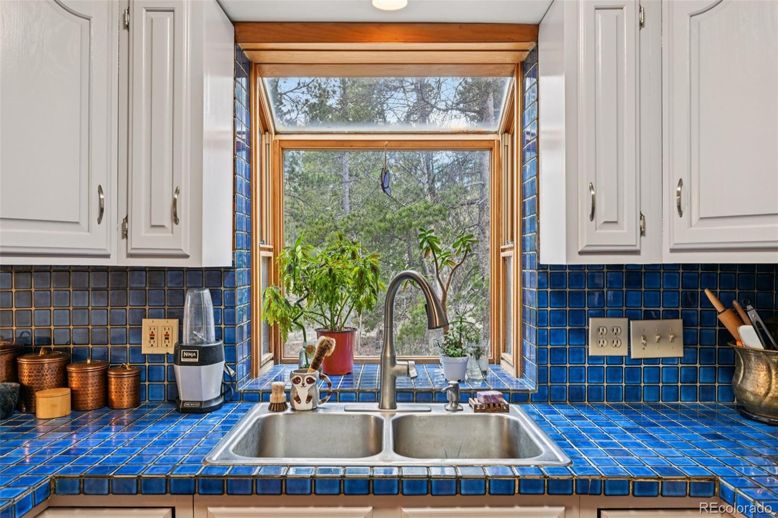 206 Pinon Circle Black Hawk, CO 80422 - Photo 13 of 50 a kitchen with sink a window and cabinets