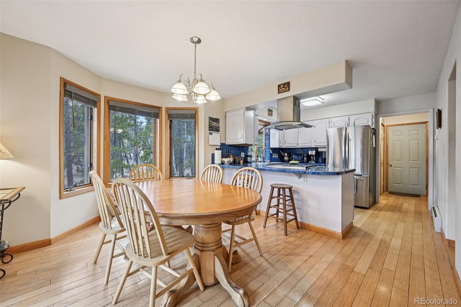 206 Pinon Circle Black Hawk, CO 80422 - Photo 15 of 50 a dining room with wooden floor a chandelier a wooden table and chairs
