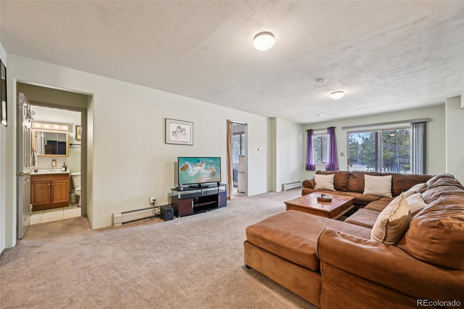 206 Pinon Circle Black Hawk, CO 80422 - Photo 39 of 50 a living room with furniture large window and a flat screen tv