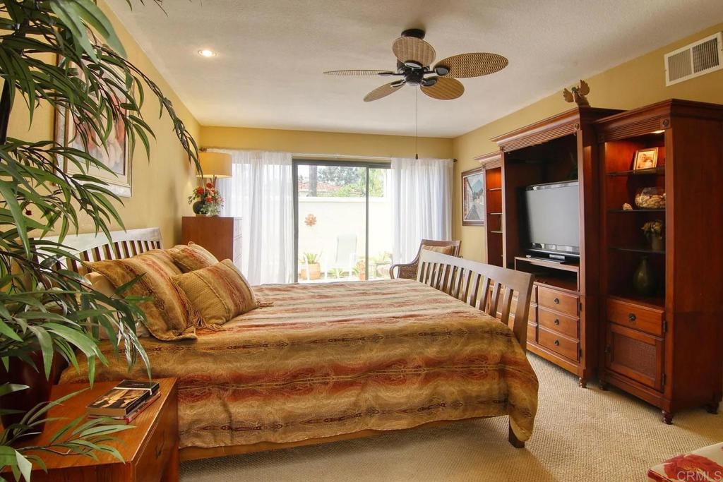 7302 Paseo Verde Carlsbad, CA 92009 - Photo 14 of 24 a bedroom with a bed and a large mirror with a flat tv screen