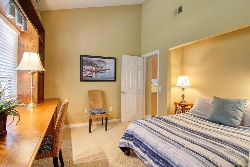 7302 Paseo Verde Carlsbad, CA 92009 - Photo 15 of 24 a bedroom with a bed and lamp next to a window