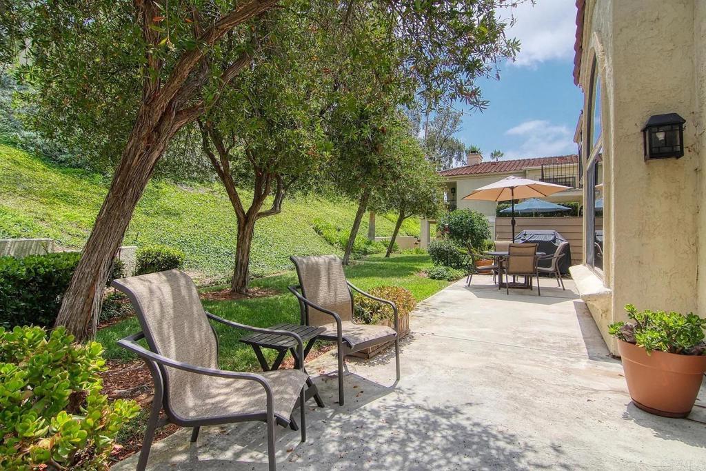 7302 Paseo Verde Carlsbad, CA 92009 - Photo 20 of 24 a view of a patio with table and chairs potted plants and a large tree