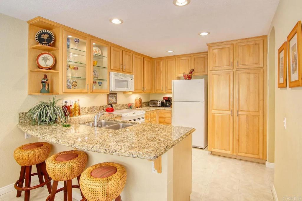7302 Paseo Verde Carlsbad, CA 92009 - Photo 5 of 24 a kitchen with granite countertop cabinets and refrigerator